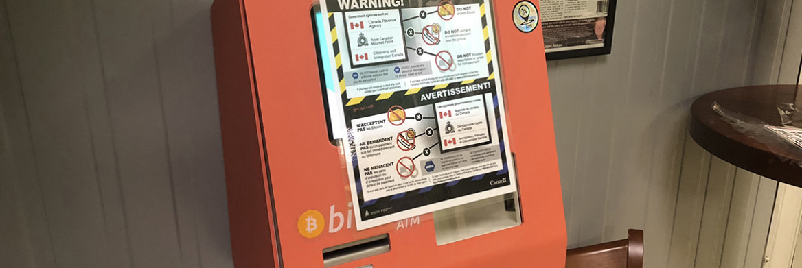 A bilingual warning poster taped to a Bitcoin ATM. 