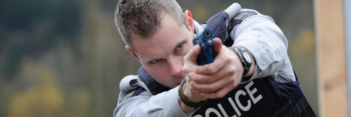Policier braquant son pistolet d'entraînement. 