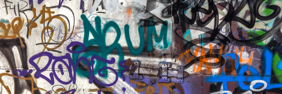 Un graffiti multicolore se trouve sur une porte métallique. 