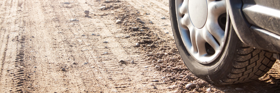 Car tire on gravel road.