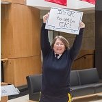The RCMP Commissioner Brenda Lucki is holding a sign above her head that reads 