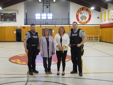 Deux policiers de la GRC à côté de deux bénévoles, dans le gymnase du centre jeunesse.