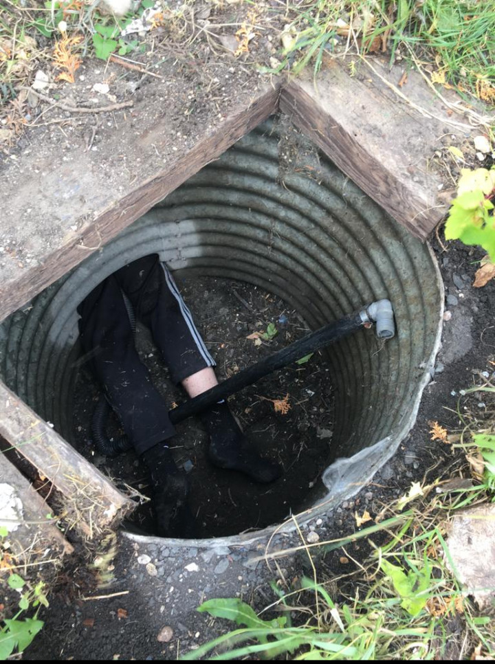 Jambes du suspect dépassant du tunnel, menant au puits.