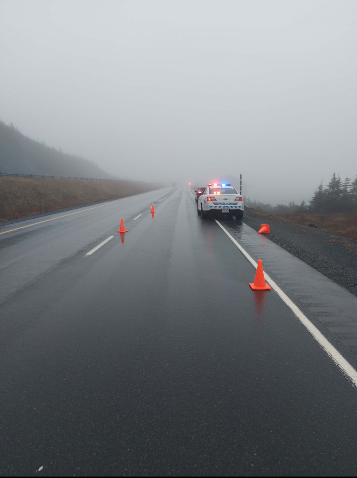 A vehicle passing by a crash scene nearly struck a marked police car on November 25, 2021, on the TCH near Holyrood Access.