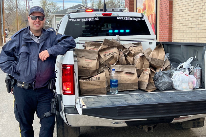 Un policier à côté d'un camion de la GRC rempli de dons alimentaires pour la banque alimentaire de Kindersley et du district.