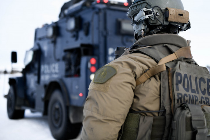 Un officier en uniforme se tient près d'un véhicule tactique