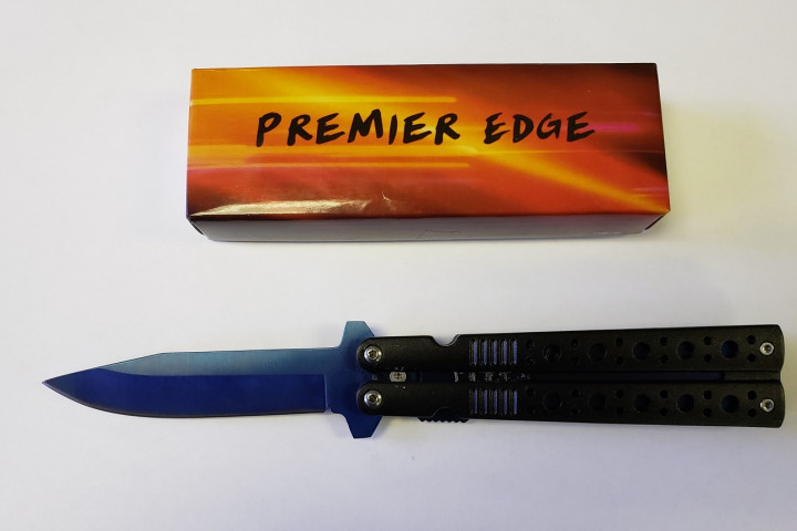 An orange and brown case, brand name Premier Edge, sits above a black switchblade knife in an open position, the blade is ejected.