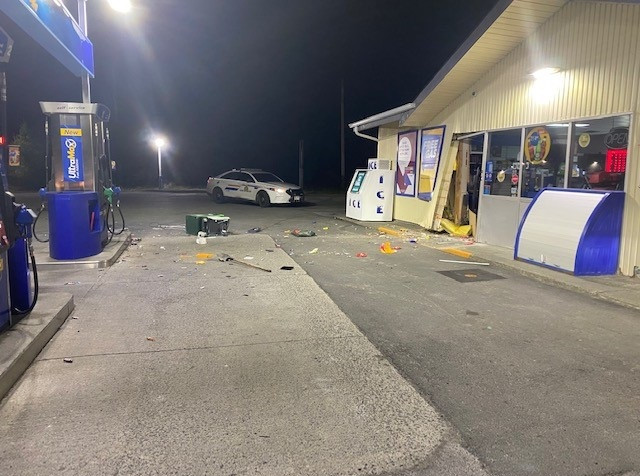 The Ultramar Gas Station building in South River is pictured with the front door broken. A marked RCMP patrol vehicle is parked on the property.