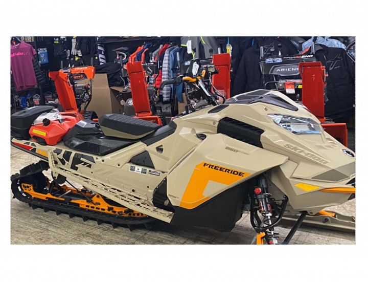 An image of a beige, orange and black snowmobile in a store.