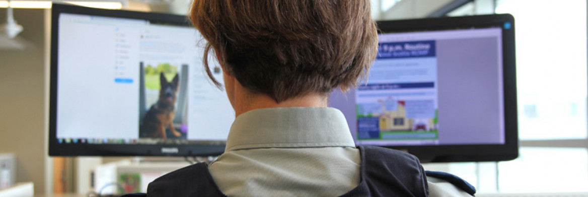Une membre de la GRC devant deux écrans d'ordinateur. 