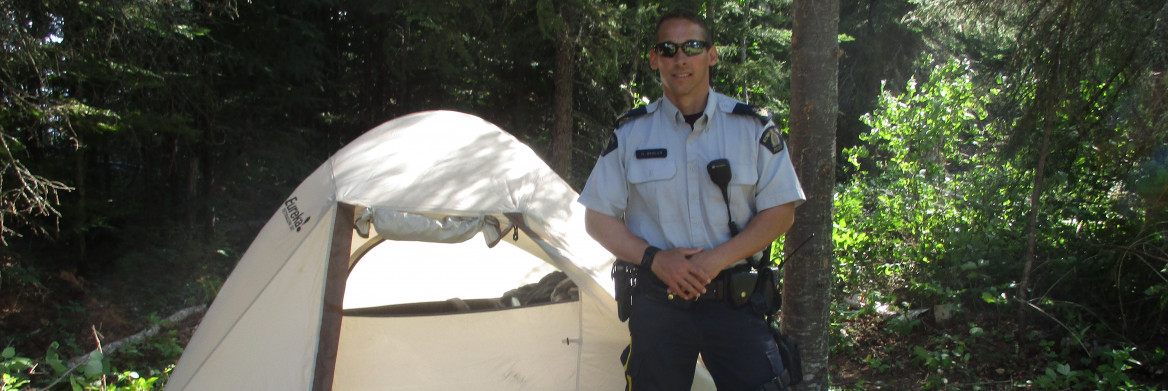 Police officer standing next to a tent.