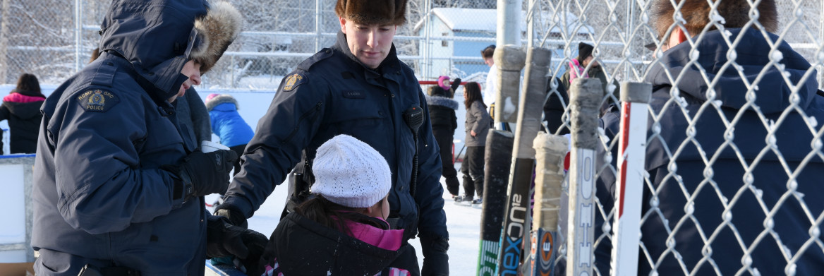 Un policier de la GRC aide un jeune patineur. 