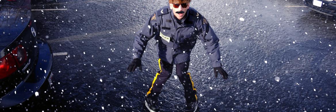 Police officer wearing skates on icy road.