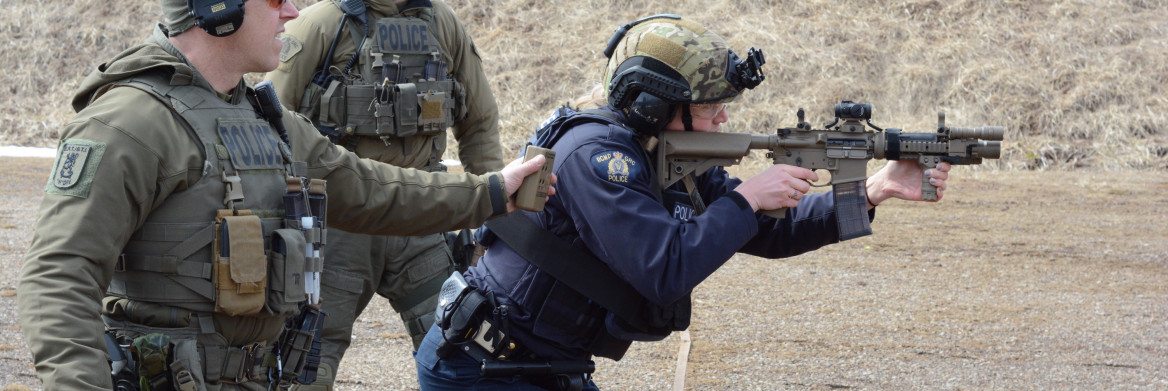 Female police officer shooting a long gun.