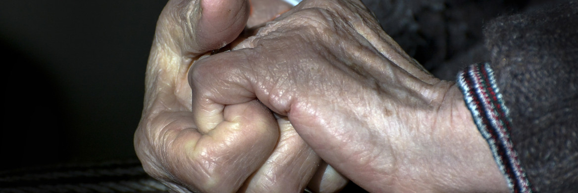 An elderly woman's hands held together tightly. 
