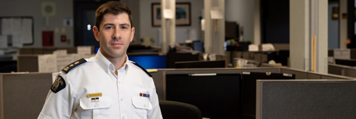 A RCMP officer stands in an office. 