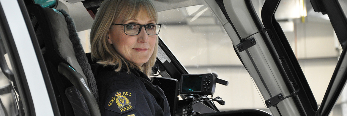 A female RCMP officer sits in a helicopter.