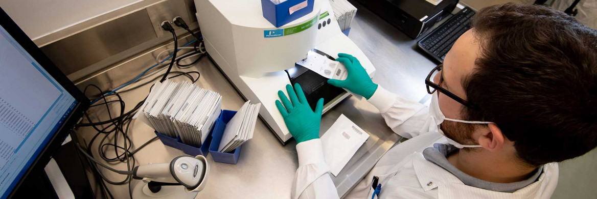 Un technicien place une carte avec un échantillon d'ADN dans une machine pour que celui-ci soit analysé.