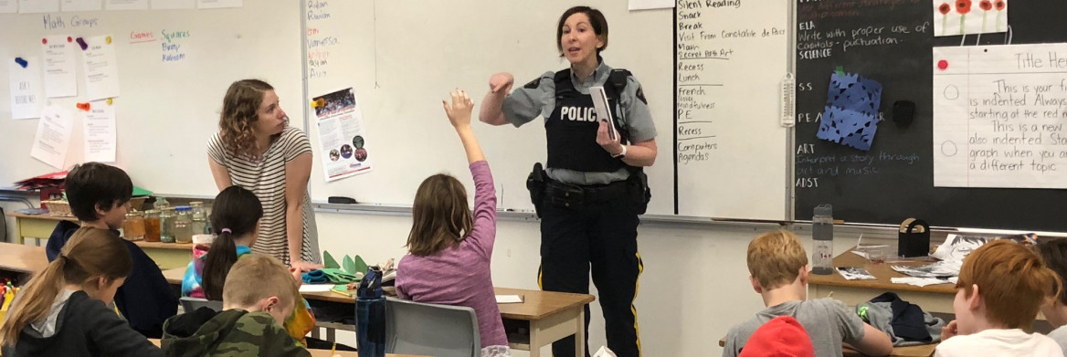 Une policière s'adresse aux élèves d'une classe.