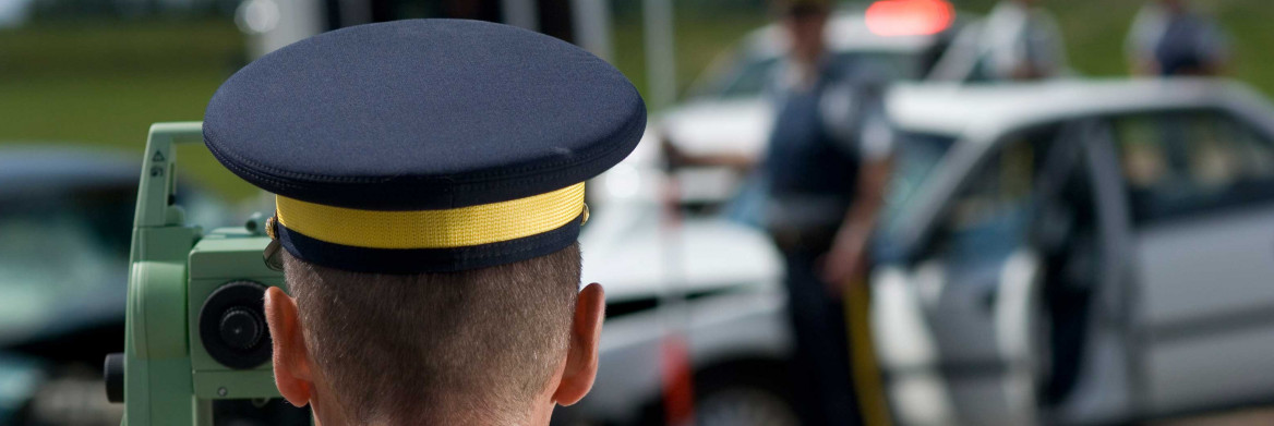 L'arrière de la tête d'un policier, regardant sur le lieu d'un accident.